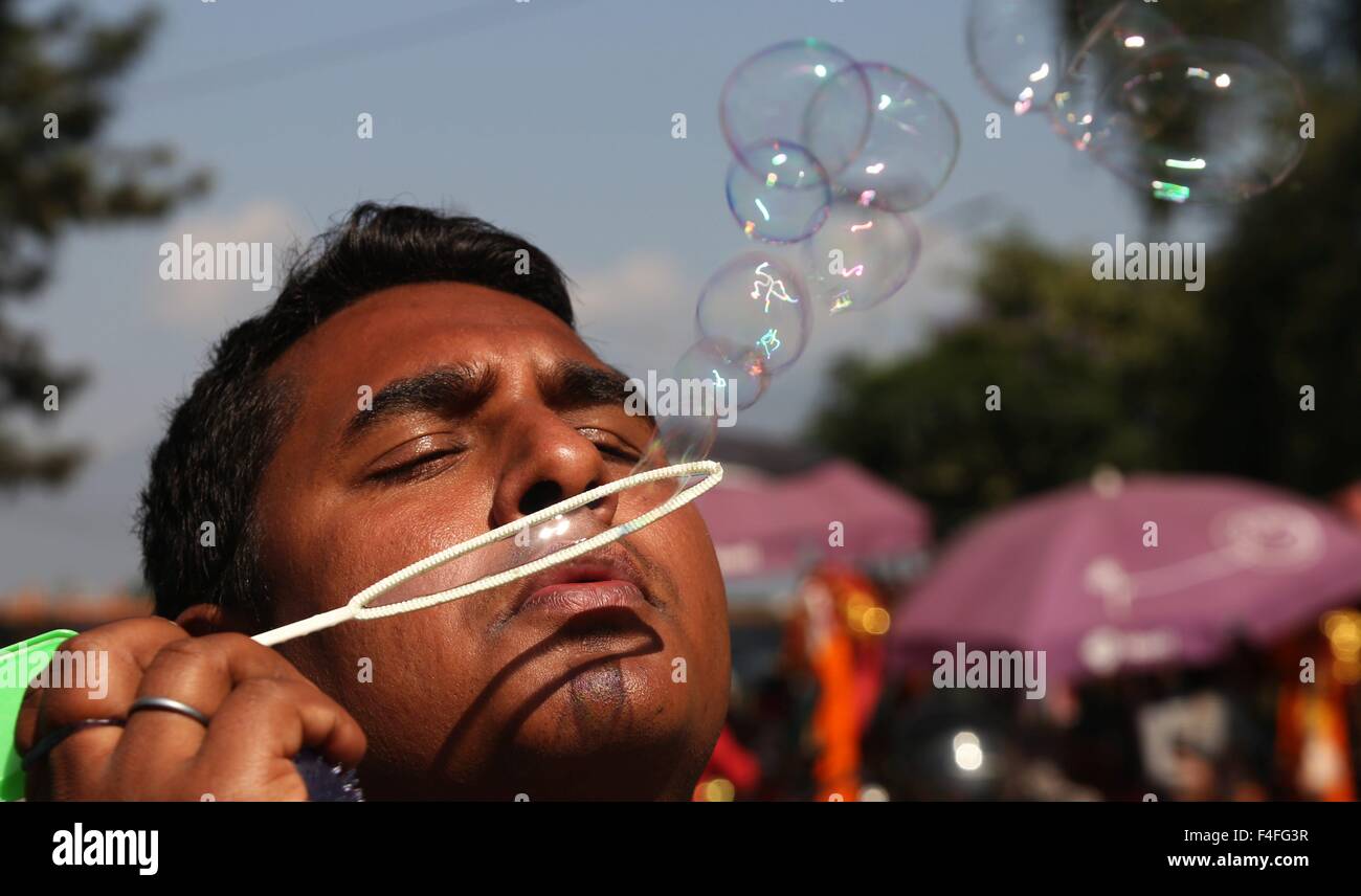 (151017) -- Kathmandu, Ottobre 17, 2015 (Xinhua) -- Un uomo Nepalese soffia bolle nella celebrazione del festival di Dashain Bhadrakali vicino tempio di Kathmandu, Nepal, Ott. 17, 2015. Gli indù in Nepal celebrare la vittoria sul male durante il festival di aquiloni mangiando, giocando sulle altalene, sacrificando gli animali e di culto della dea Durga nonché altri dei e dee. (Xinhua/Sunil Sharma) Foto Stock