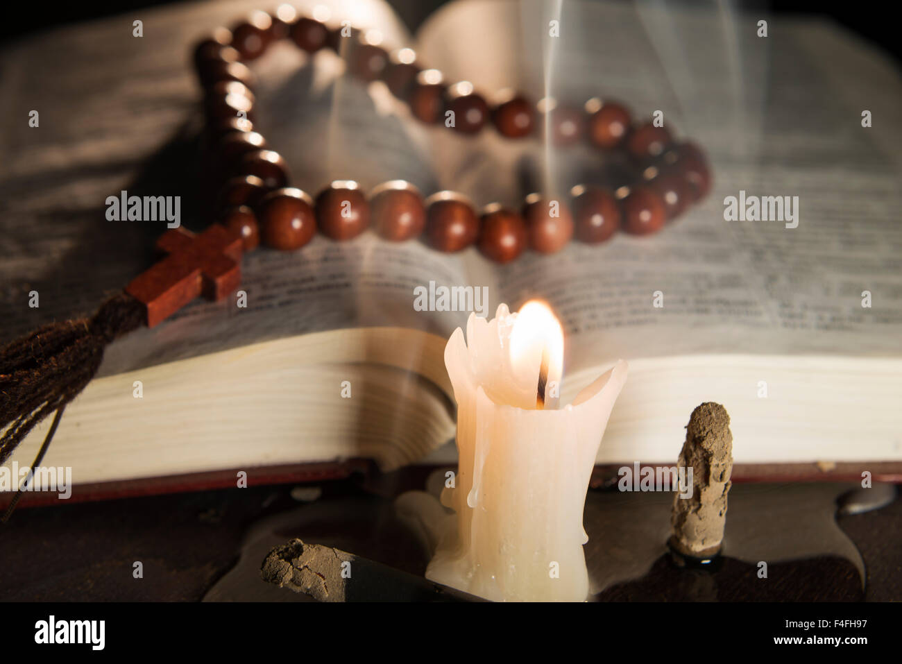 Candela con incenso e libro sacro Foto Stock