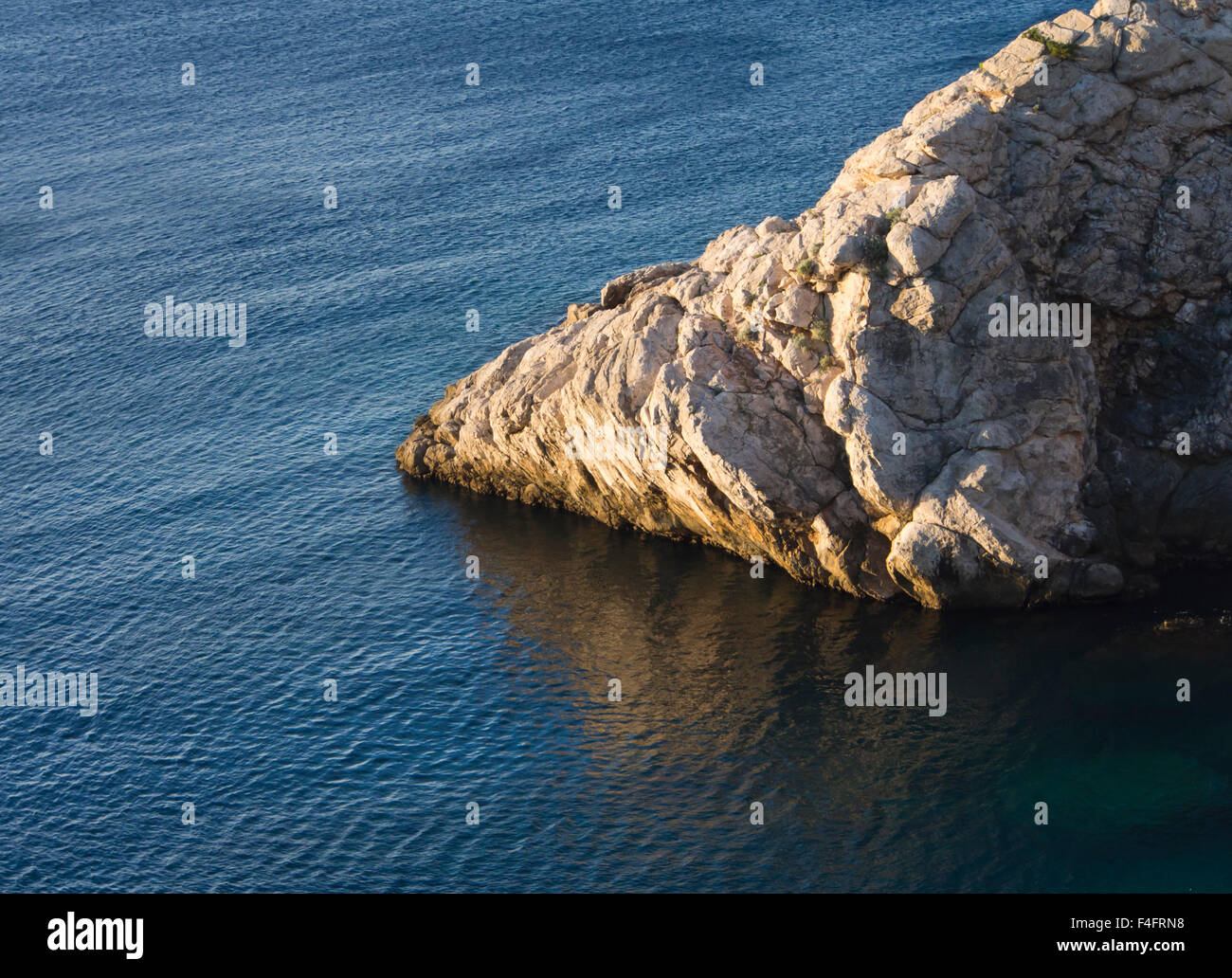 Cliff nella luce del sole giallo , blu mare, impressione della costa dalmata Foto Stock