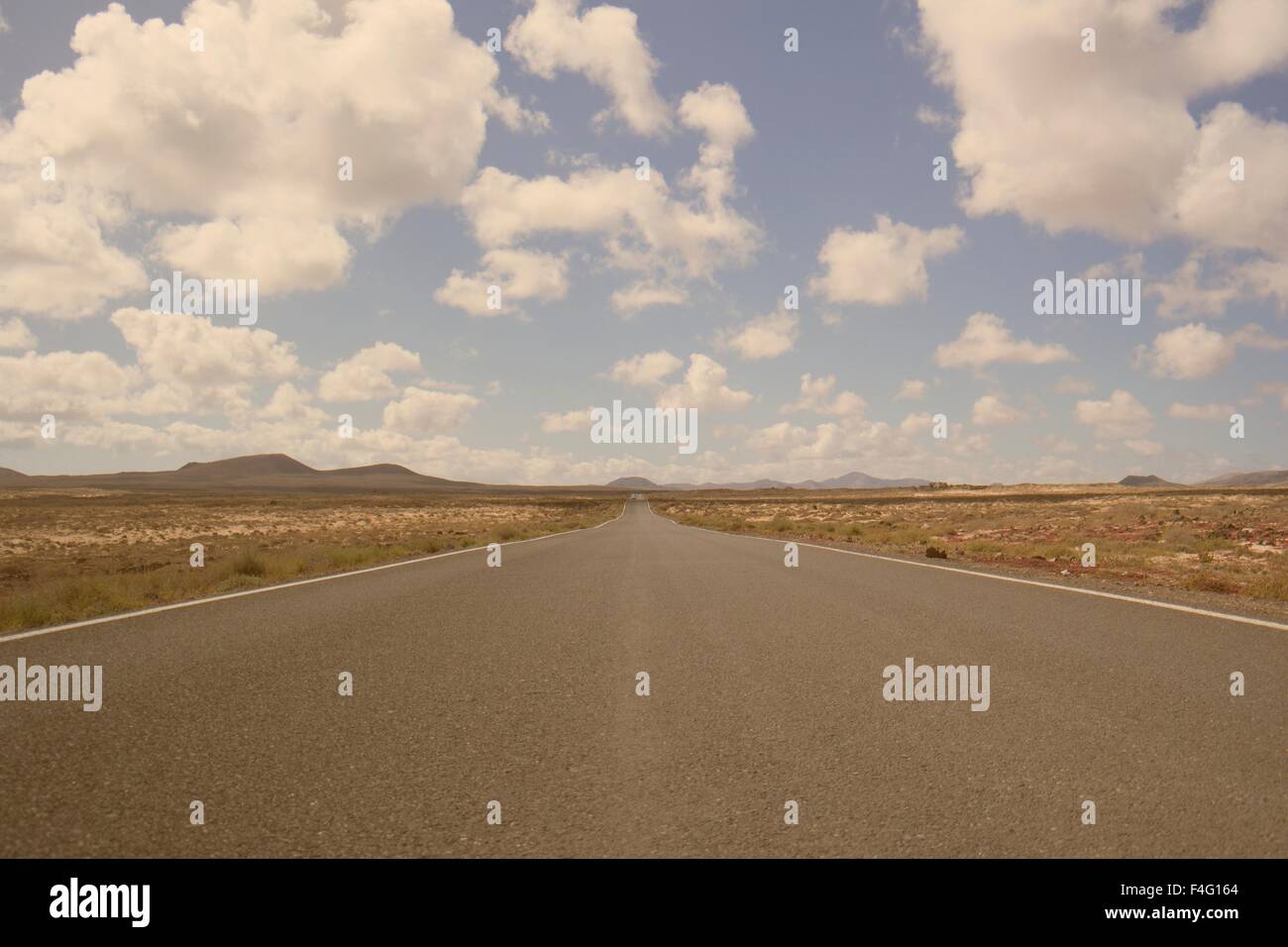 Strada solitaria all'orizzonte è interrotta tra il deserto e le nuvole Foto Stock
