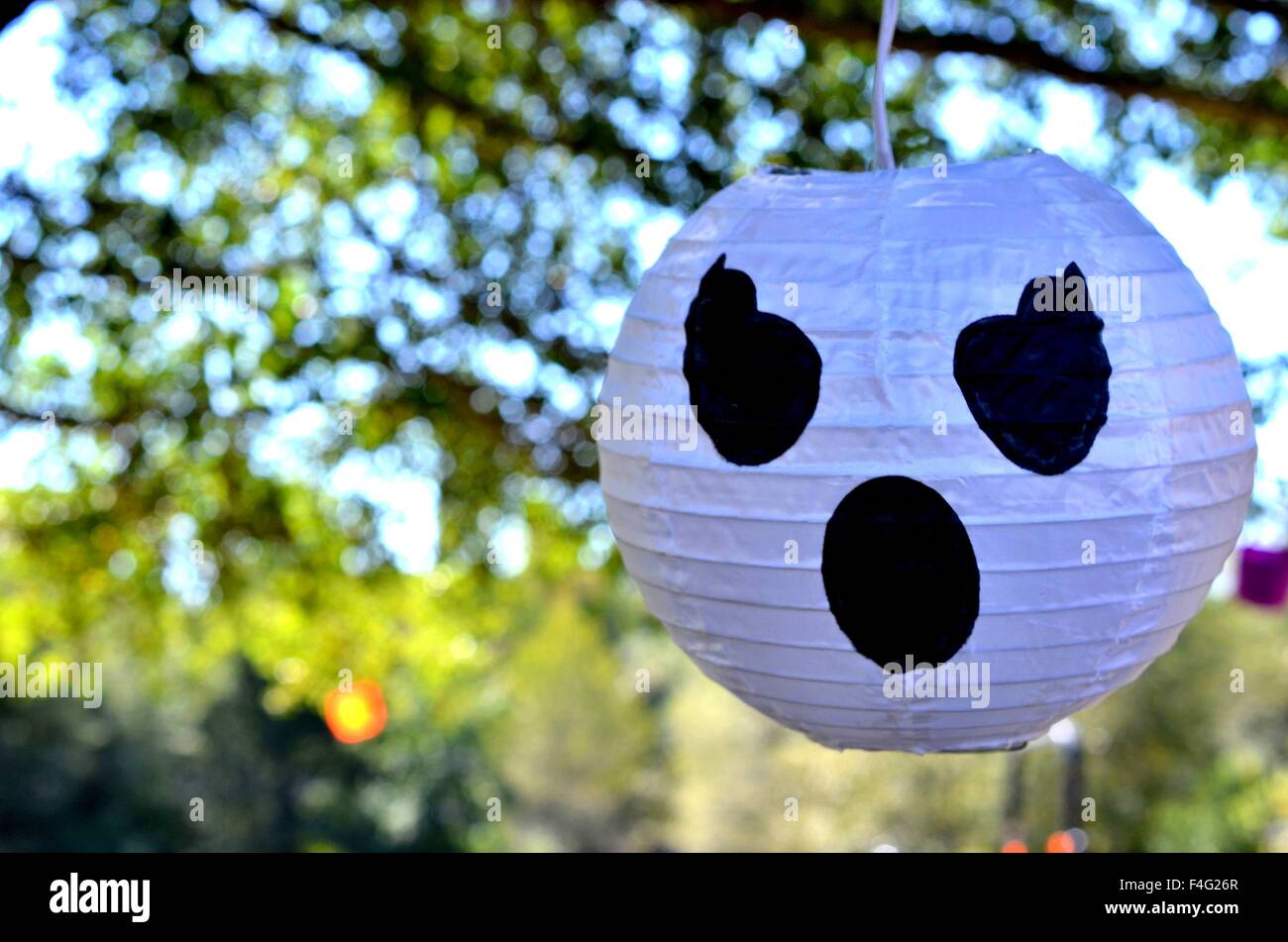 Decorazione di Halloween di un volto bianco, ghost, zucca, appeso a un albero. Foto Stock