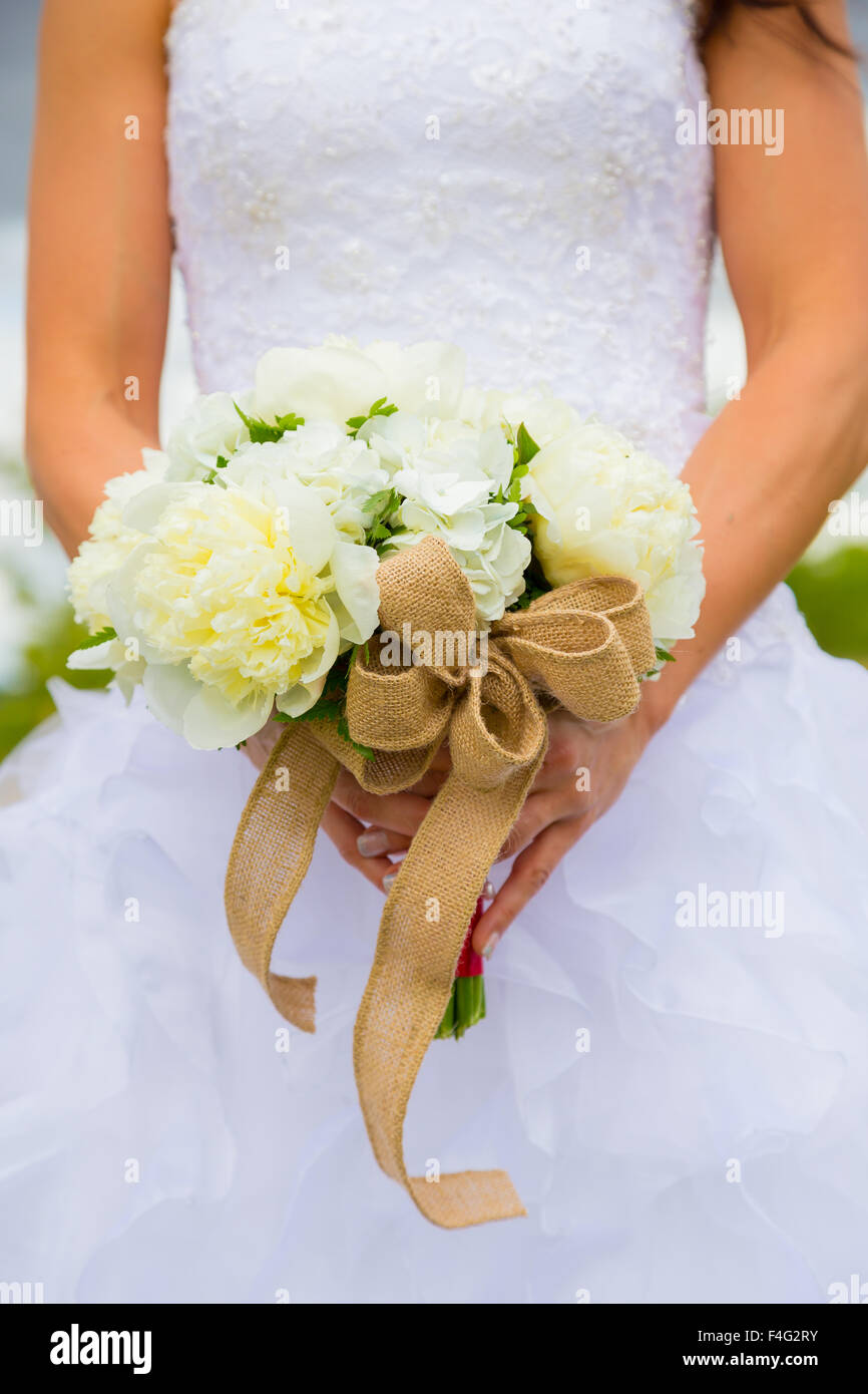 Fiori bianchi in un mazzo tenuto da sposa il giorno delle nozze. Foto Stock