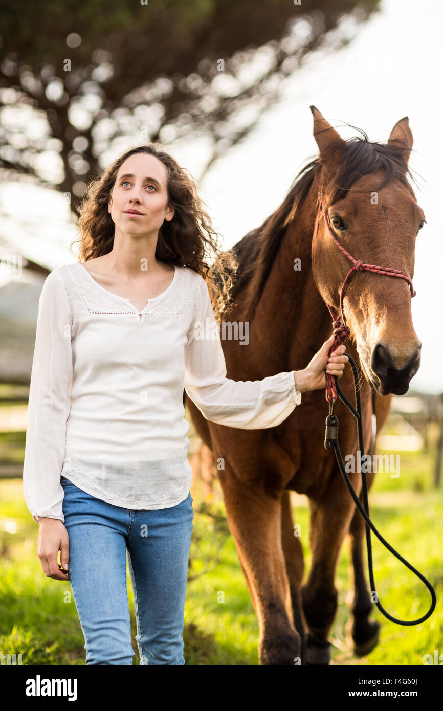 Giovane Donna che cammina con il suo cavallo Foto Stock