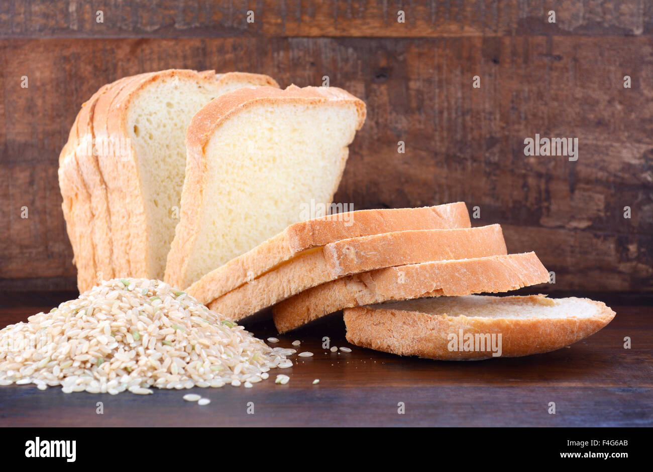 Senza glutine di riso a fette di pasta acida pane con materie riso marrone sul legno scuro dello sfondo della tabella. Foto Stock