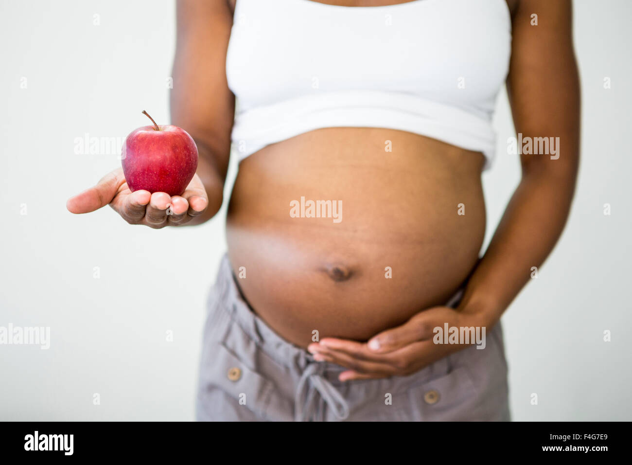 Donna incinta tenendo un Apple Foto Stock