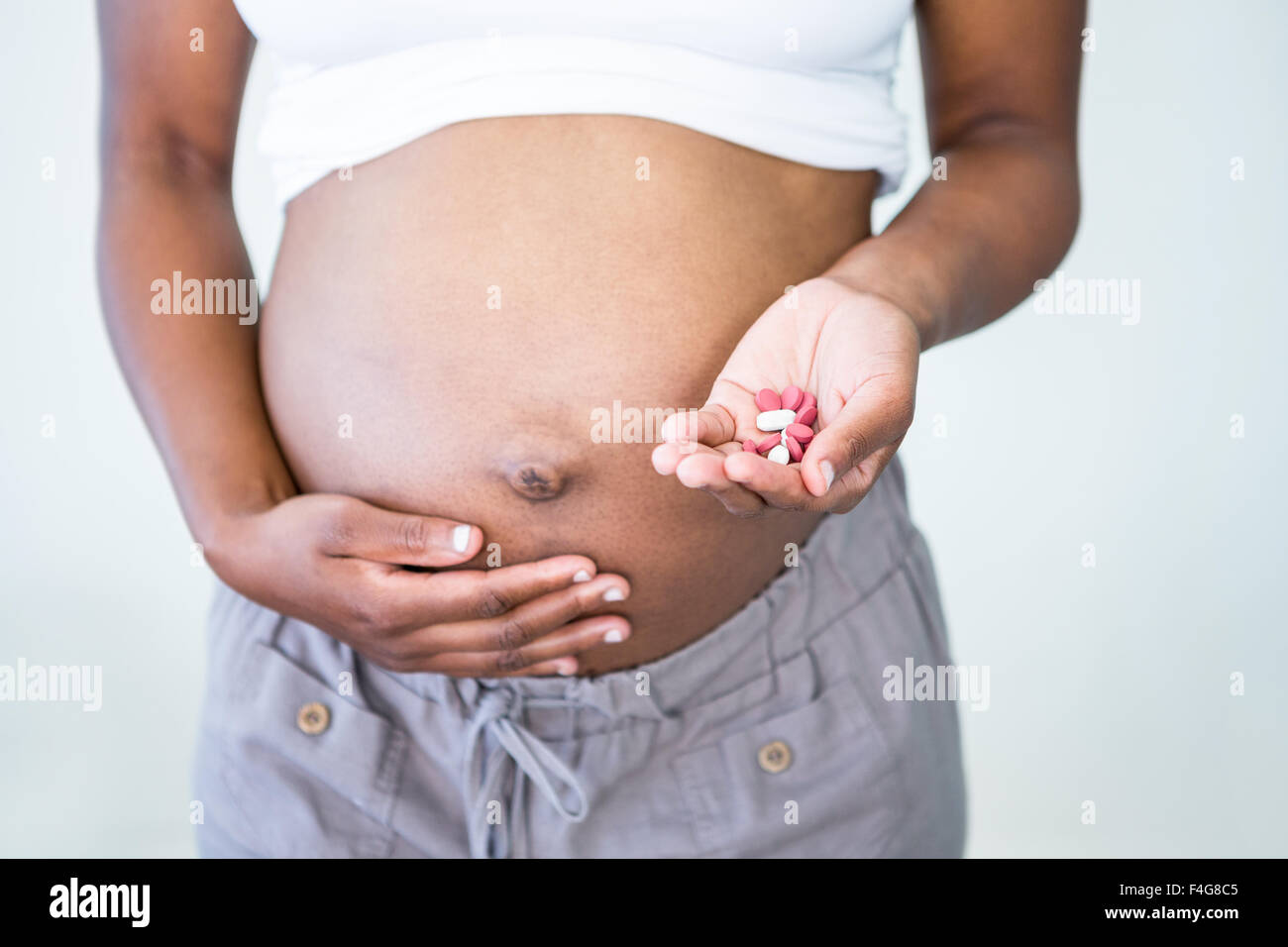 Donna incinta azienda pillole in mano Foto Stock