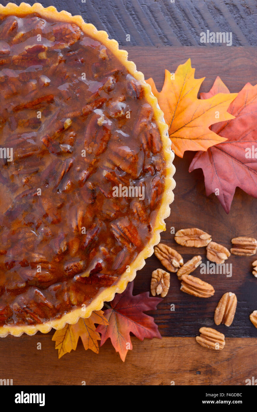 Felice ringraziamento tradizionale torta alle noci pecan su vintage legno scuro tavolo e sfondo con foglie di autunno. Foto Stock