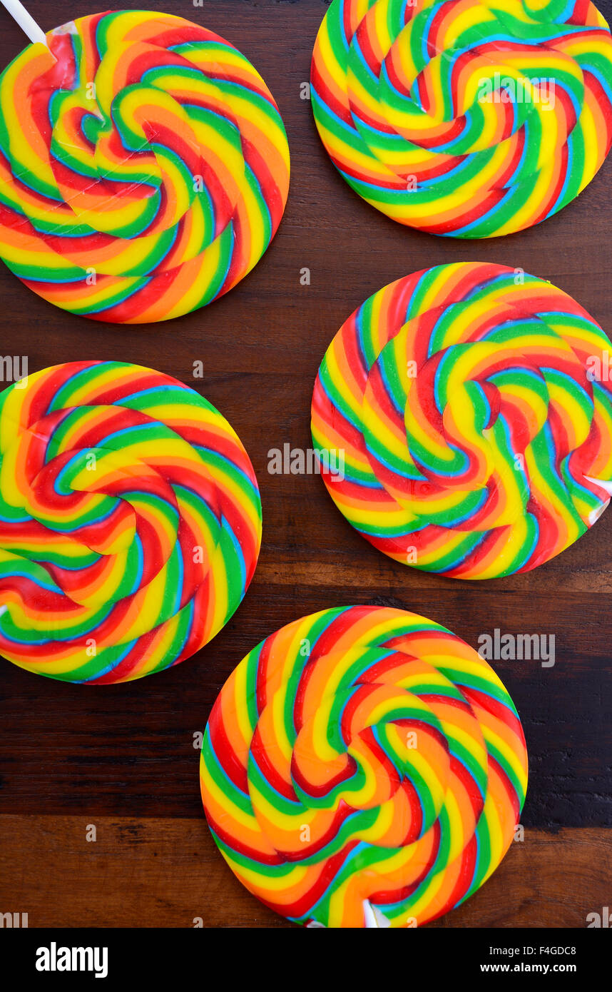 Bright rainbow lollipop candy sul legno scuro tavolo. Foto Stock