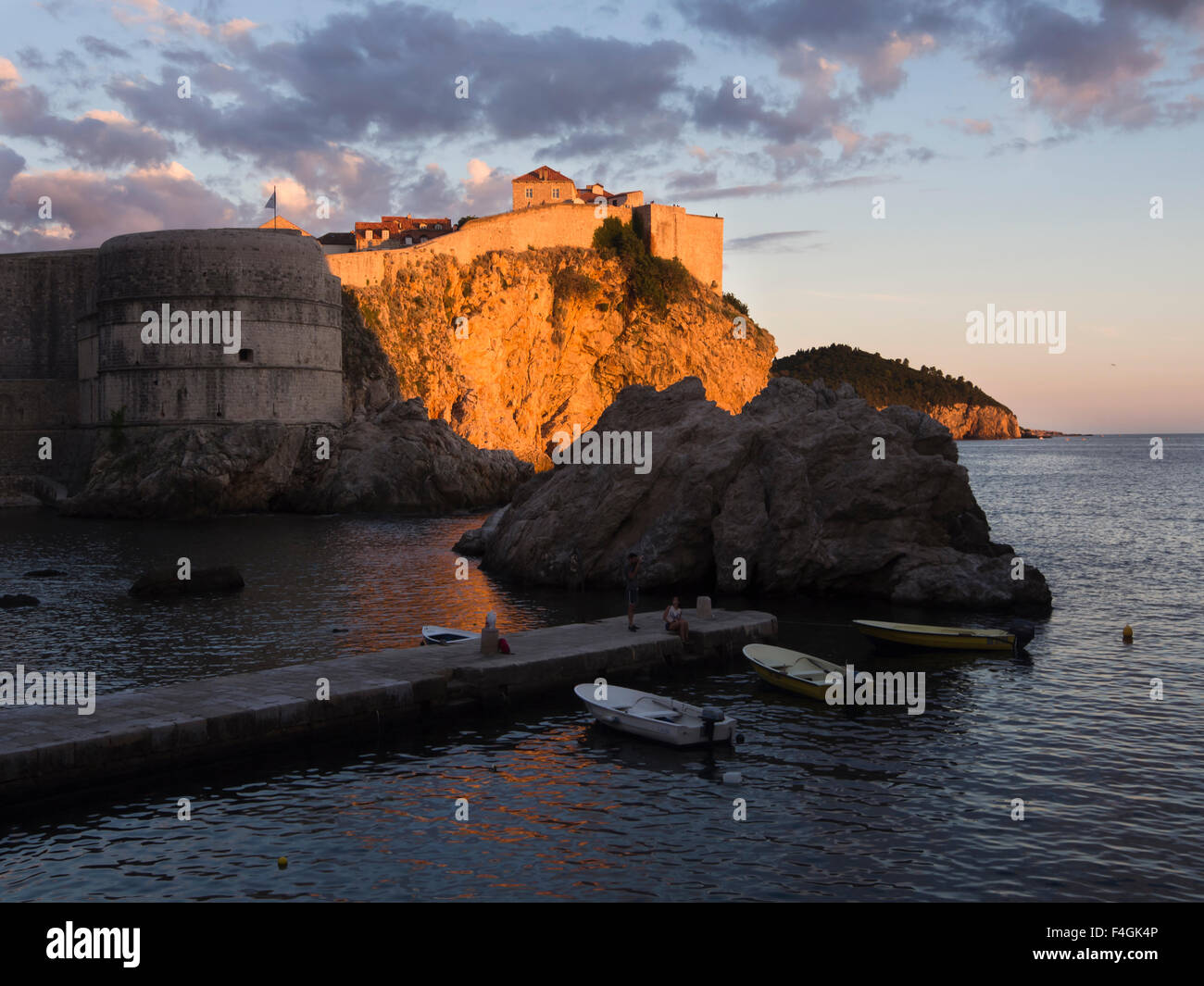 Tramonto sulla costa dalmata del mare adriatico rende le scogliere e alle mura della vecchia città diventano dorate, Dubrovnik Croazia Foto Stock