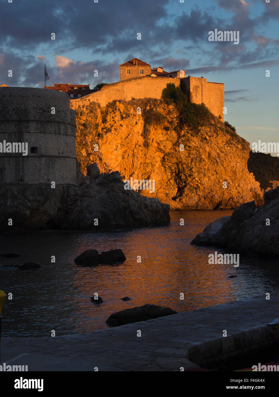 Tramonto sulla costa dalmata del mare adriatico rende le scogliere e alle mura della vecchia città diventano dorate, Dubrovnik Croazia Foto Stock