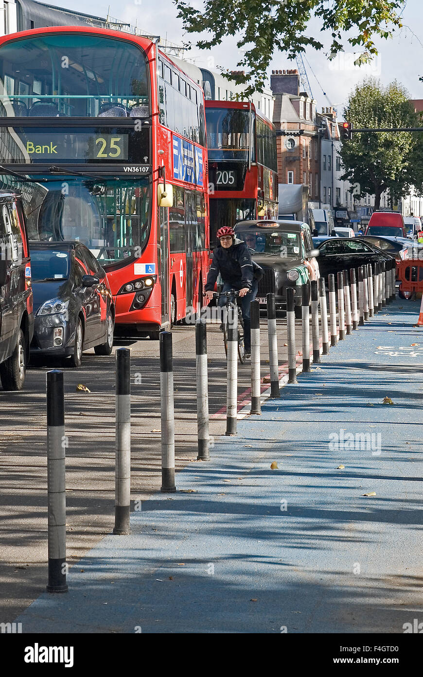 Accodamento di traffico su una strada a Whitechapel, East London come continuo investimento in segregata infrastruttura ciclismo spreme spazio stradale per i veicoli. Foto Stock