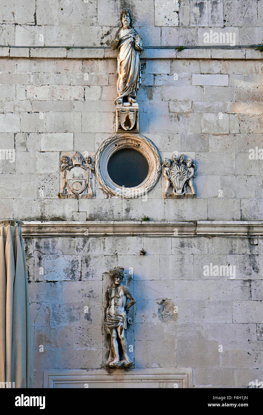 Trogir, Croazia - City Hall, dettaglio della torre muro di pietra con statue e stemmi Foto Stock