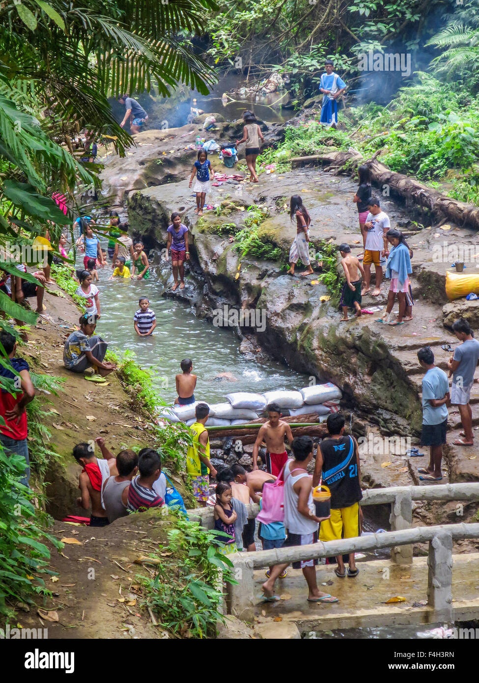 Area Rurale le famiglie filippine godetevi un pomeriggio di nuotare in un torrente di montagna vicino la loro città. Foto Stock