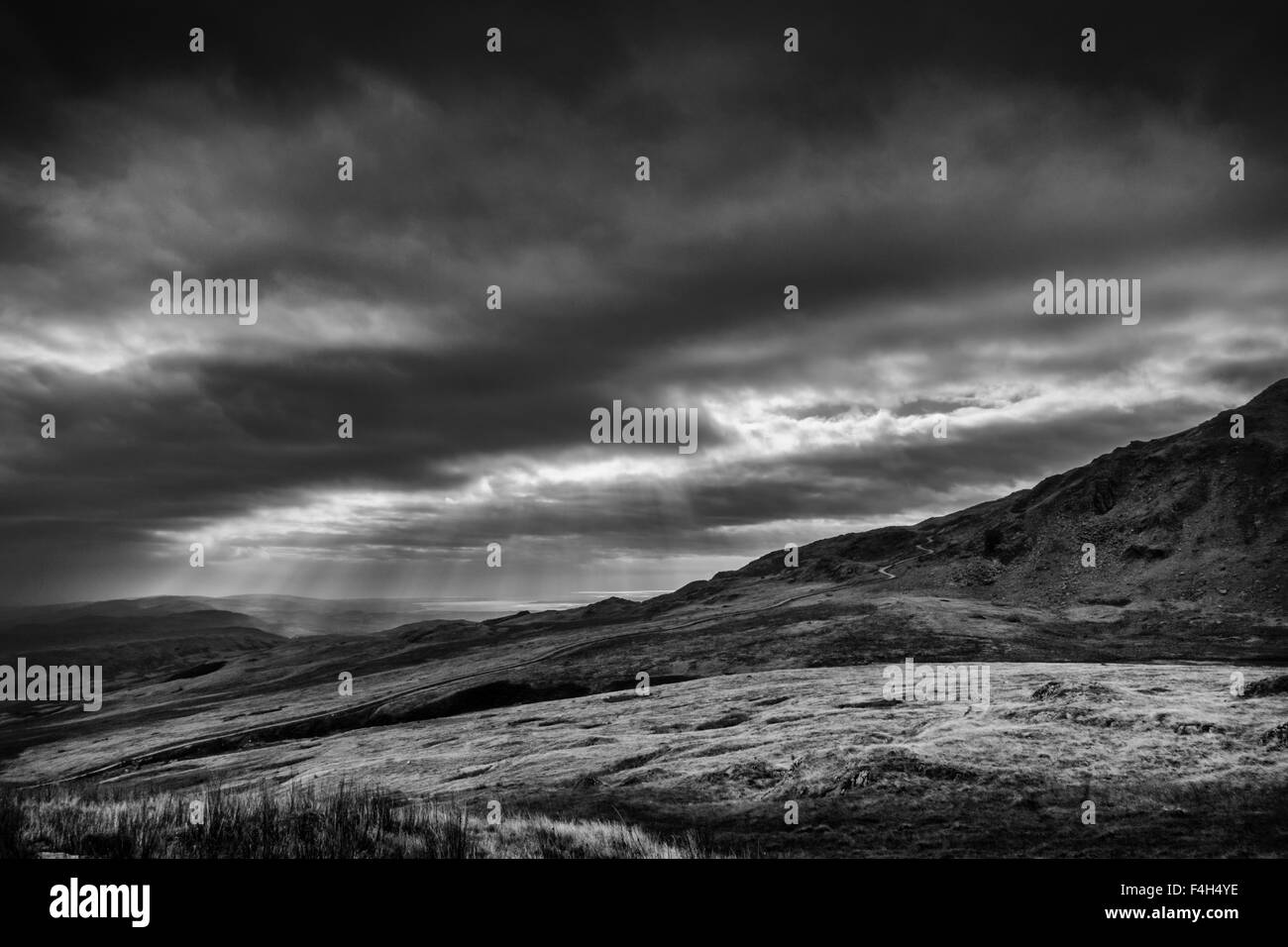 Paesaggi: raggi crepuscolari dal vecchio uomo di Coniston e Dow Crag nel Parco Nazionale del Distretto dei Laghi, con cicatrice Walna Road Foto Stock