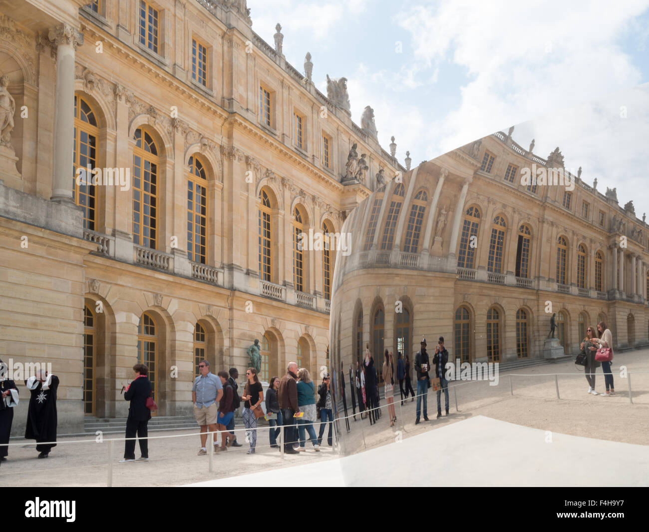 Il Palazzo di Versailles e i visitatori si riflette in Anish Kapoor curva C scultura installazione presso il Palace Gardens Foto Stock