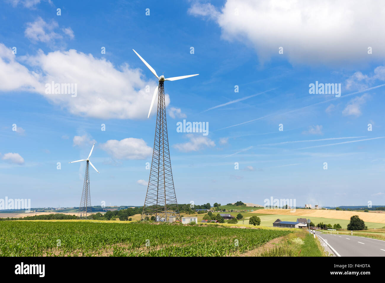 Due mulini a vento in campagna con il cielo blu e nuvole bianche in Germania Foto Stock