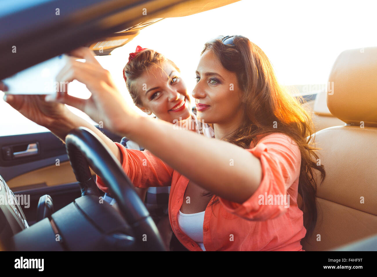 Due giovani belle ragazze stanno facendo una foto di te stesso in una cabriolet Foto Stock
