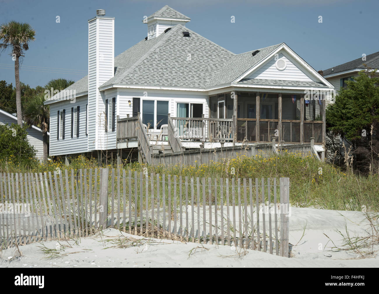 La stoltezza Beach, Carolina del Sud, Stati Uniti d'America. Xvii oct, 2015. Multi-colore di case sulla spiaggia siediti nelle dune lungo follia Beach, Carolina del Sud, appena a sud di Charleston. La stoltezza Beach è una delle diverse aree lungo la costa vicino a Charleston con spiaggia case e villette e case utilizzato come una seconda casa per vacanze e week end. I colori e il layout variano con la maggior parte dei disegni, a basso profilo eaves, persiane e costruzione robusta, tenendo conto delle condizioni climatiche avverse, i venti forti e pioggia compresi uragani. Molte case scelgono di avere una passerella in legno rialzata a span basse dune mobili e praterie con scalinate desce Foto Stock