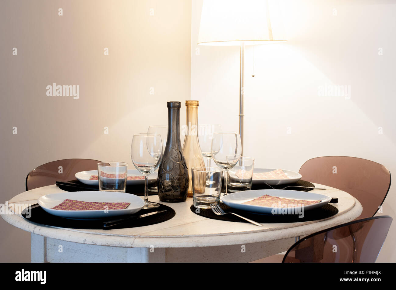 Round set table in una casa in stile rustico di luce di colori marrone, lampada in background Foto Stock