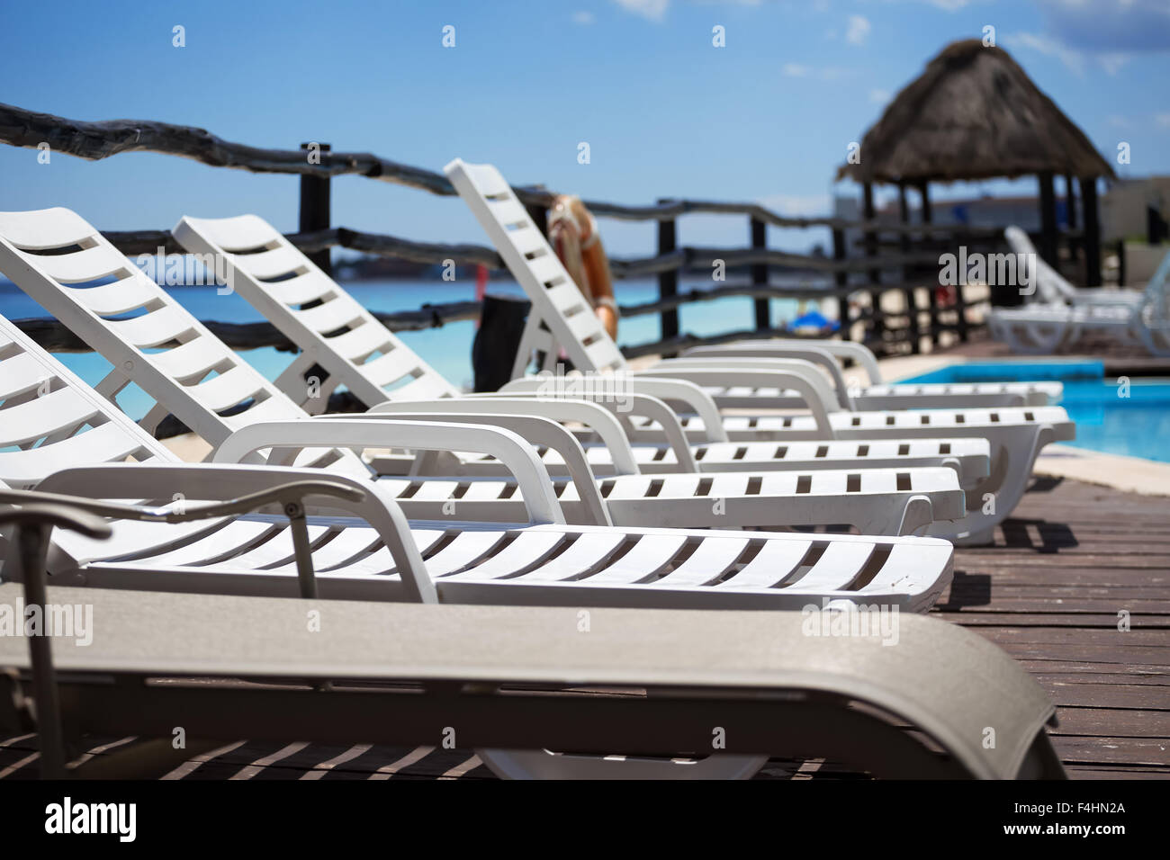 Lounge lettini vicino alla piscina, vicino al Mar dei Caraibi Foto Stock