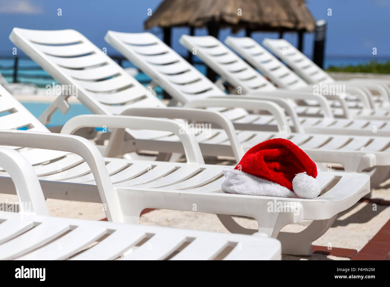 Santa Claus Hat sul lettino vicino alla piscina. Vacanze di Natale concept Foto Stock