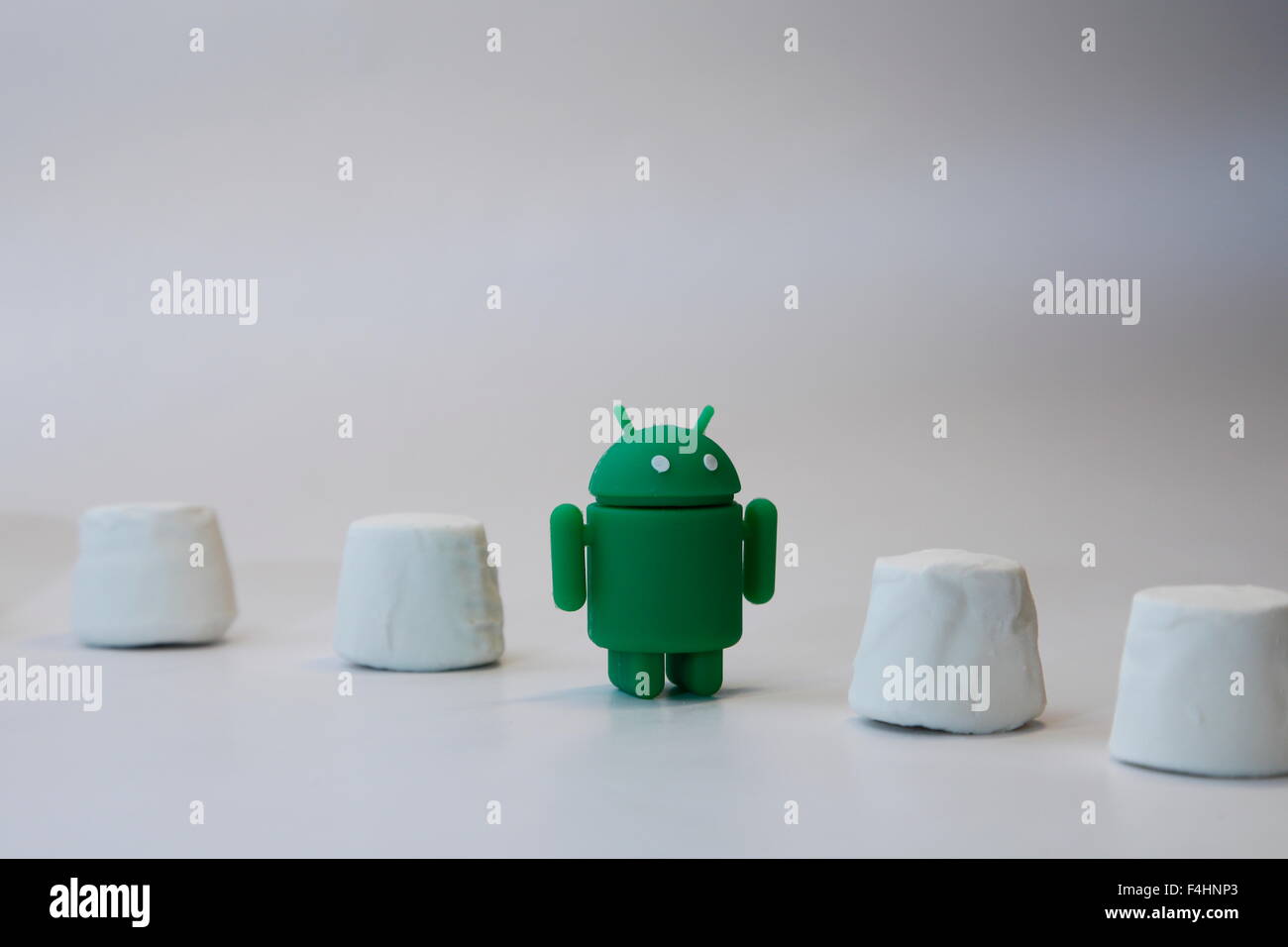 Un verde robot androide coetanei dall'interno di una pila di marshmallows. Google Android OS è denominata marshmallow Foto Stock