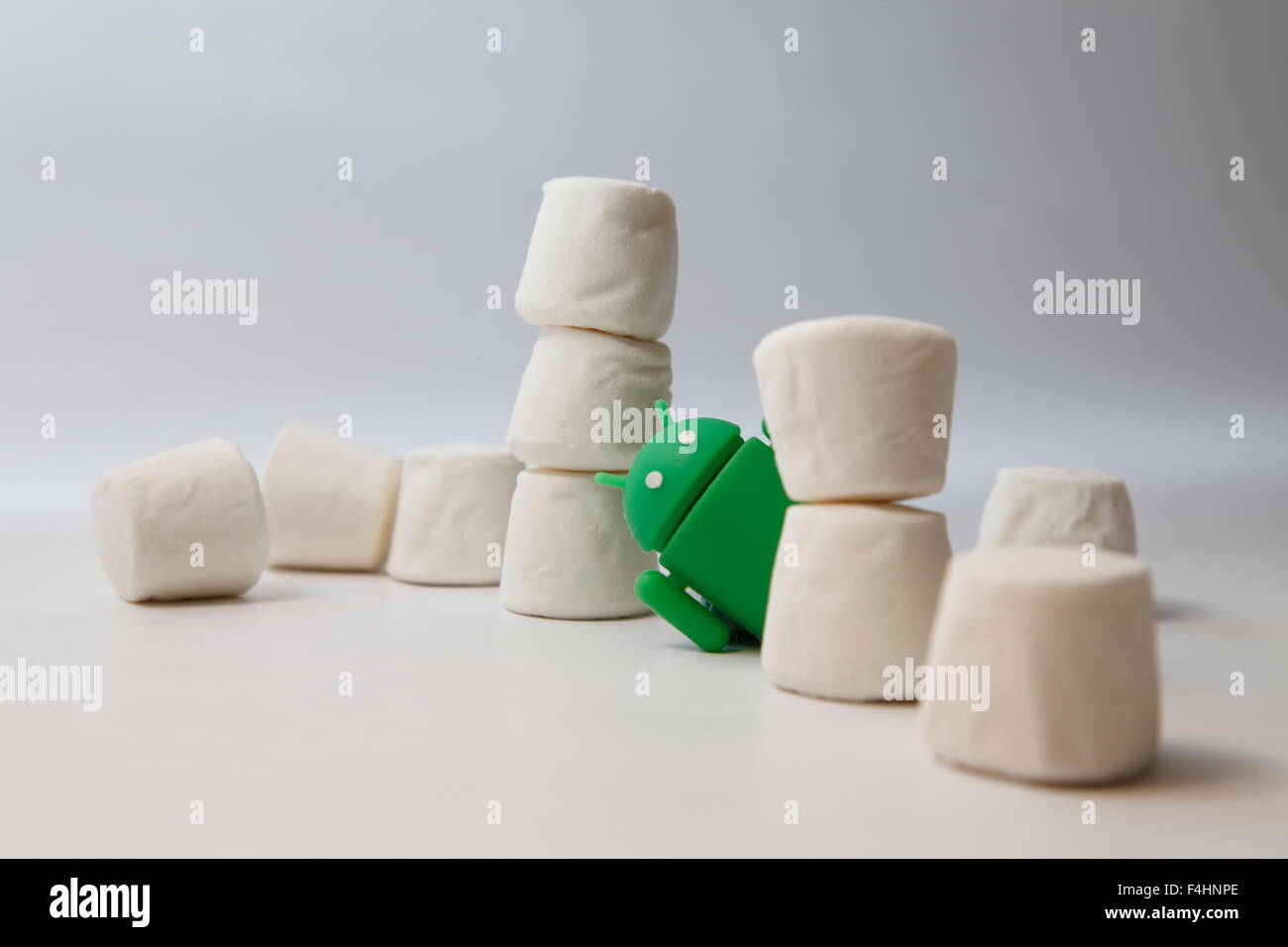 Un verde robot androide coetanei dall'interno di una pila di marshmallows. Google Android OS è denominata marshmallow Foto Stock