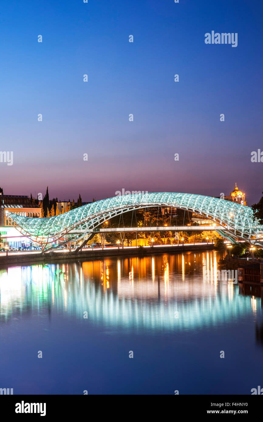 Vista del tramonto del ponte di pace, un pedone ponte che attraversa il fiume Mtkvari a Tbilisi, capitale della Georgia. Foto Stock