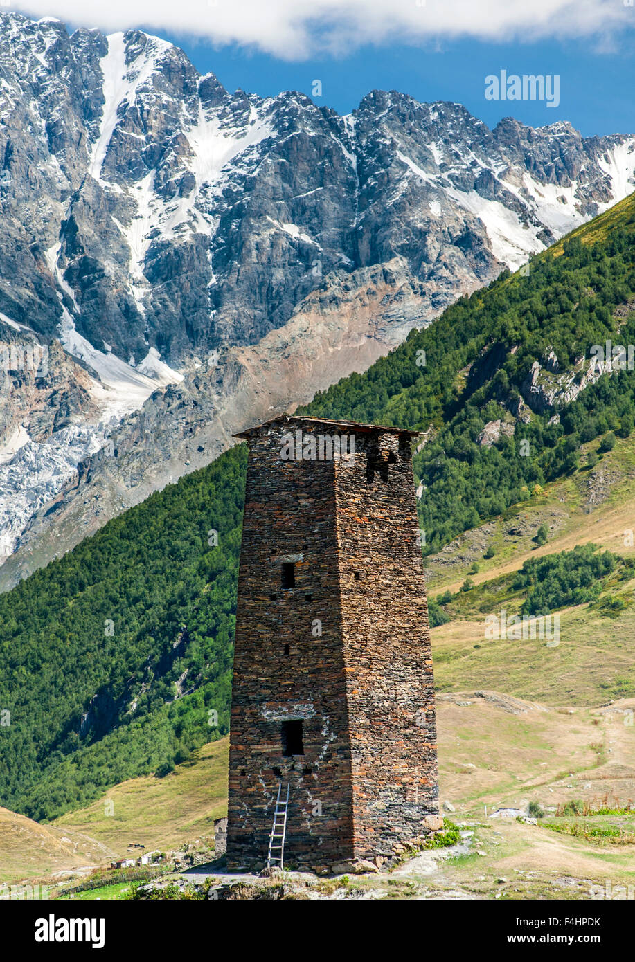 Torre Svan nel villaggio di Ushguli nella regione di Svaneti del nord ovest della Georgia. Sullo sfondo il Monte Shkhara. Foto Stock