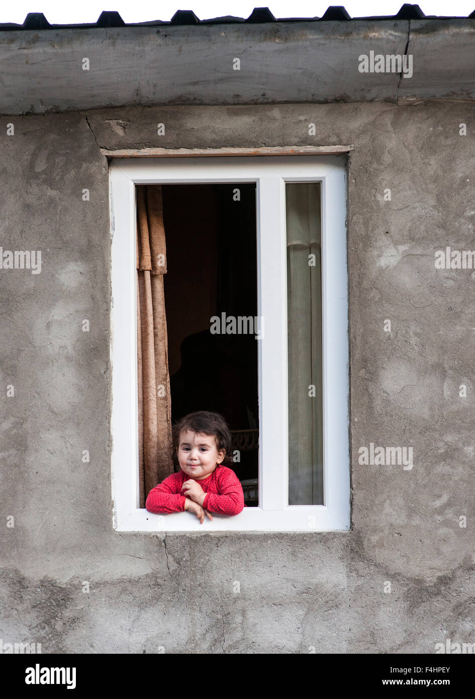 Una giovane ragazza alla finestra di una casa in Ushguli nel distretto di Svaneti, montagne del Caucaso, northwestern Georgia. Foto Stock