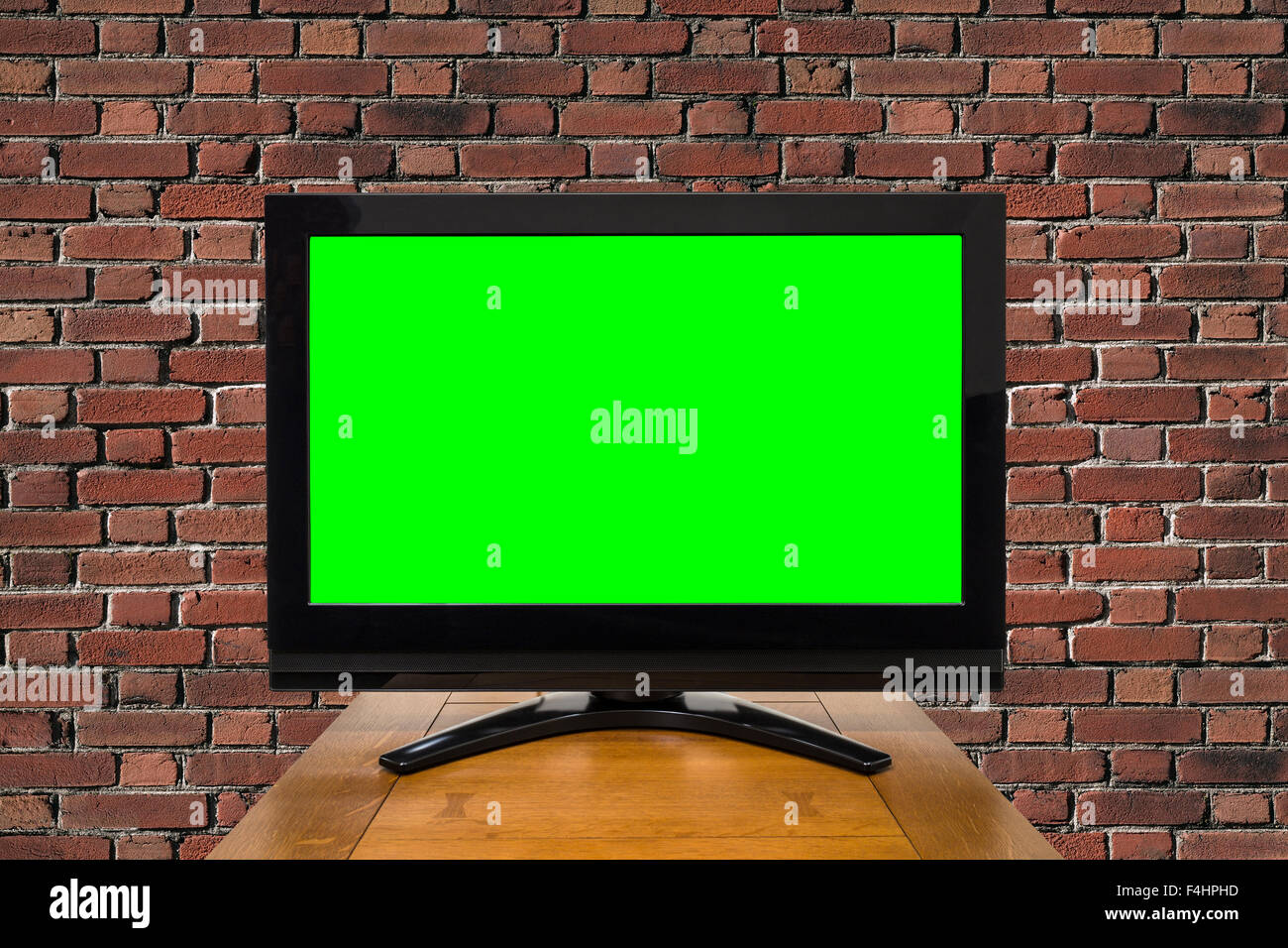 Televisore moderno con chroma key schermo verde e rosso un muro di mattoni. Foto Stock
