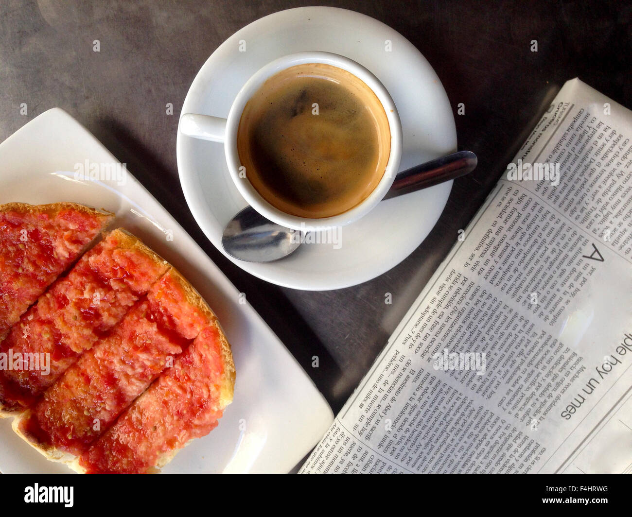 Prima colazione spagnola con caffè, tomatoe toast e newpaper Foto Stock
