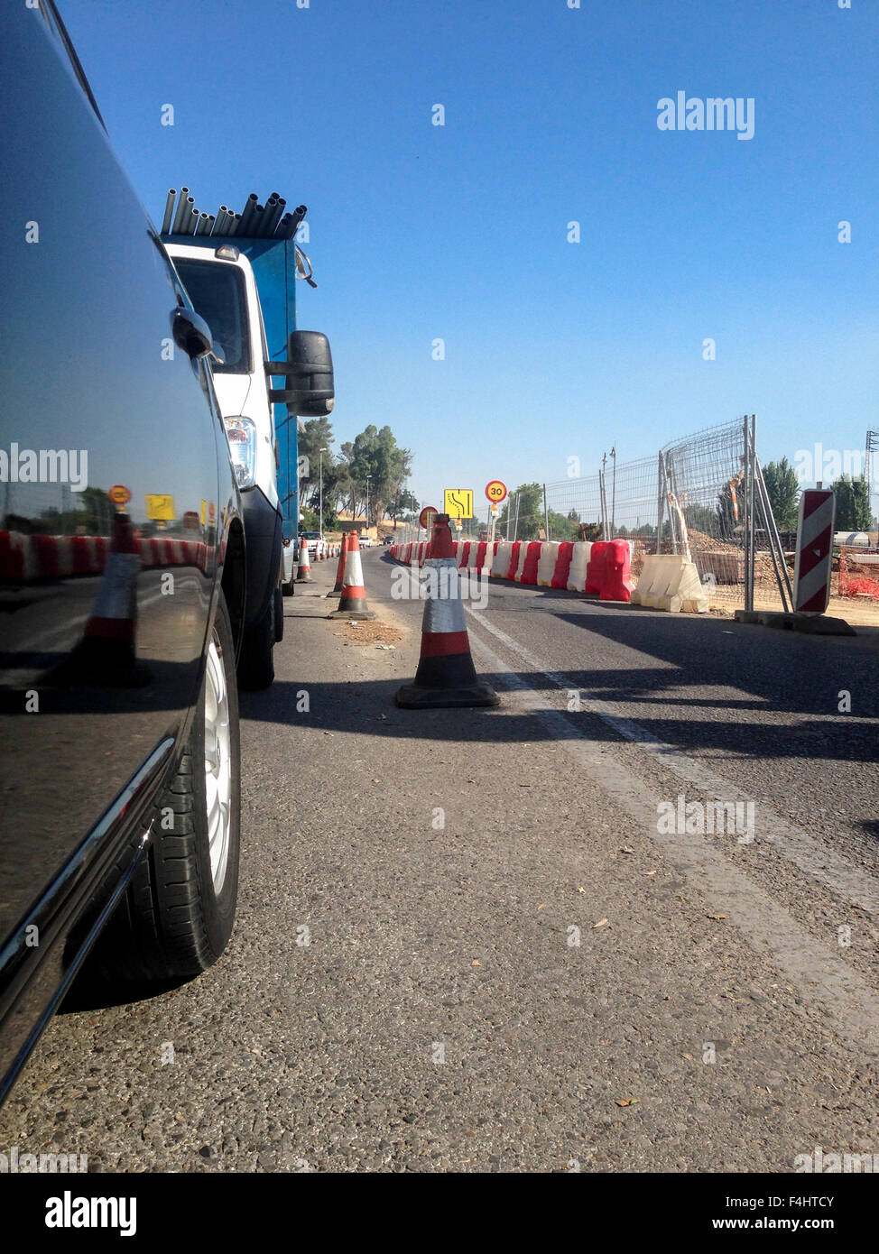 I veicoli in attesa in linea poiché le attività di costruzione su strada Foto Stock