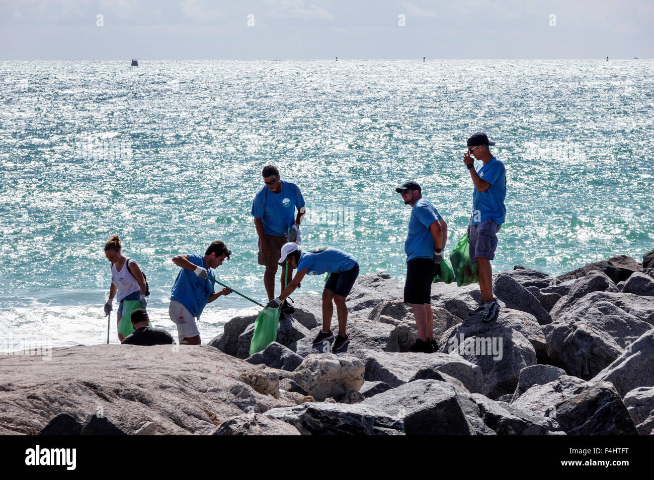 Miami Beach Florida, pulizia-up, volontari volontariato, lavoro di squadra che lavorano insieme uomini donne, raccolta rifiuti rifiuti rifiuti di impatto Day Oceano Atlantico Foto Stock