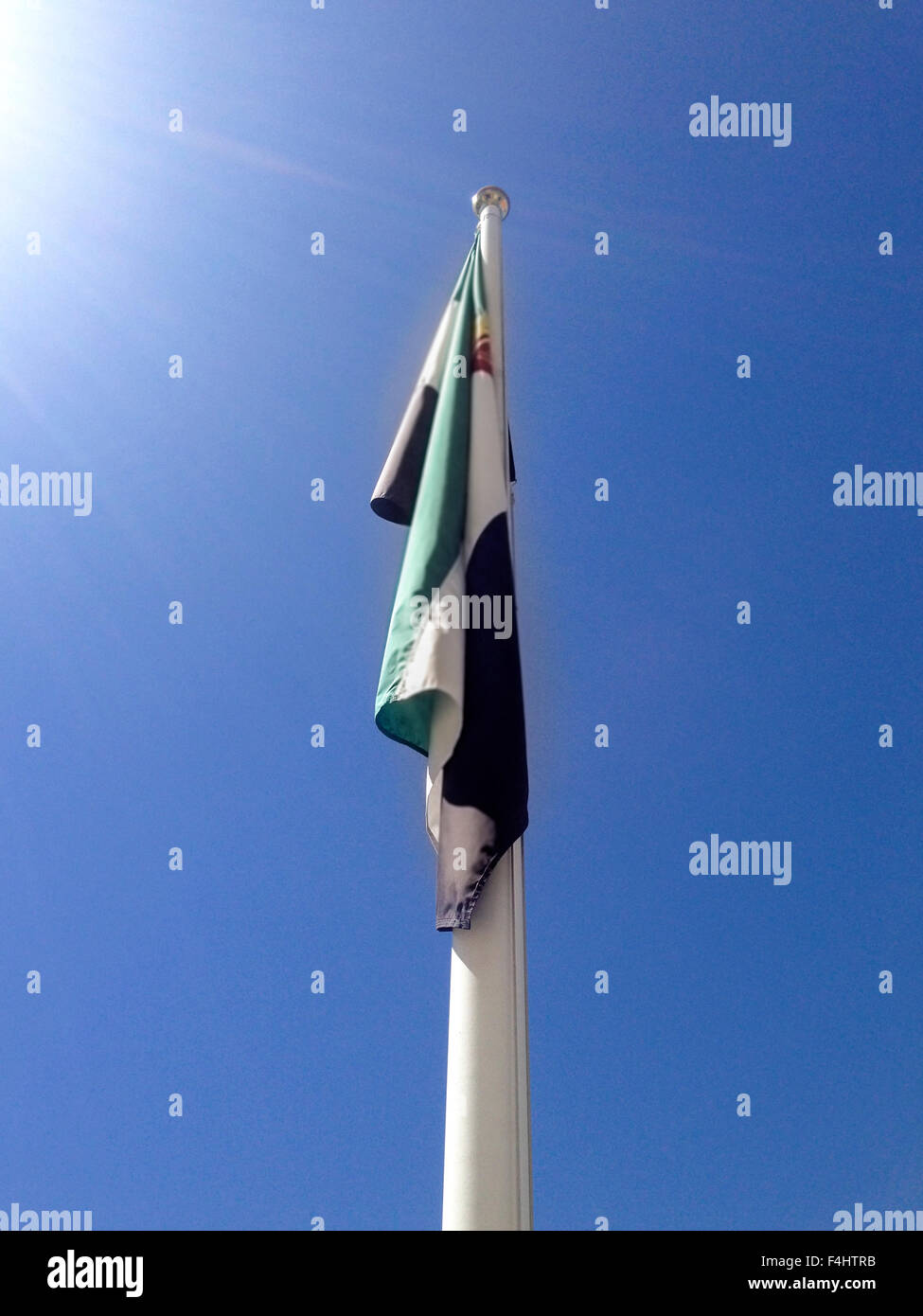 Regione dell'Extremadura bandiera sul pennone di una giornata soleggiata con cielo blu Foto Stock