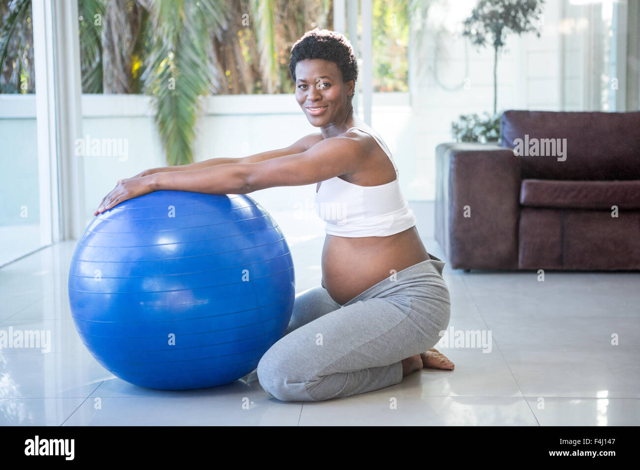 Ritratto di Allegro donna incinta che esercitano con sfera Foto Stock