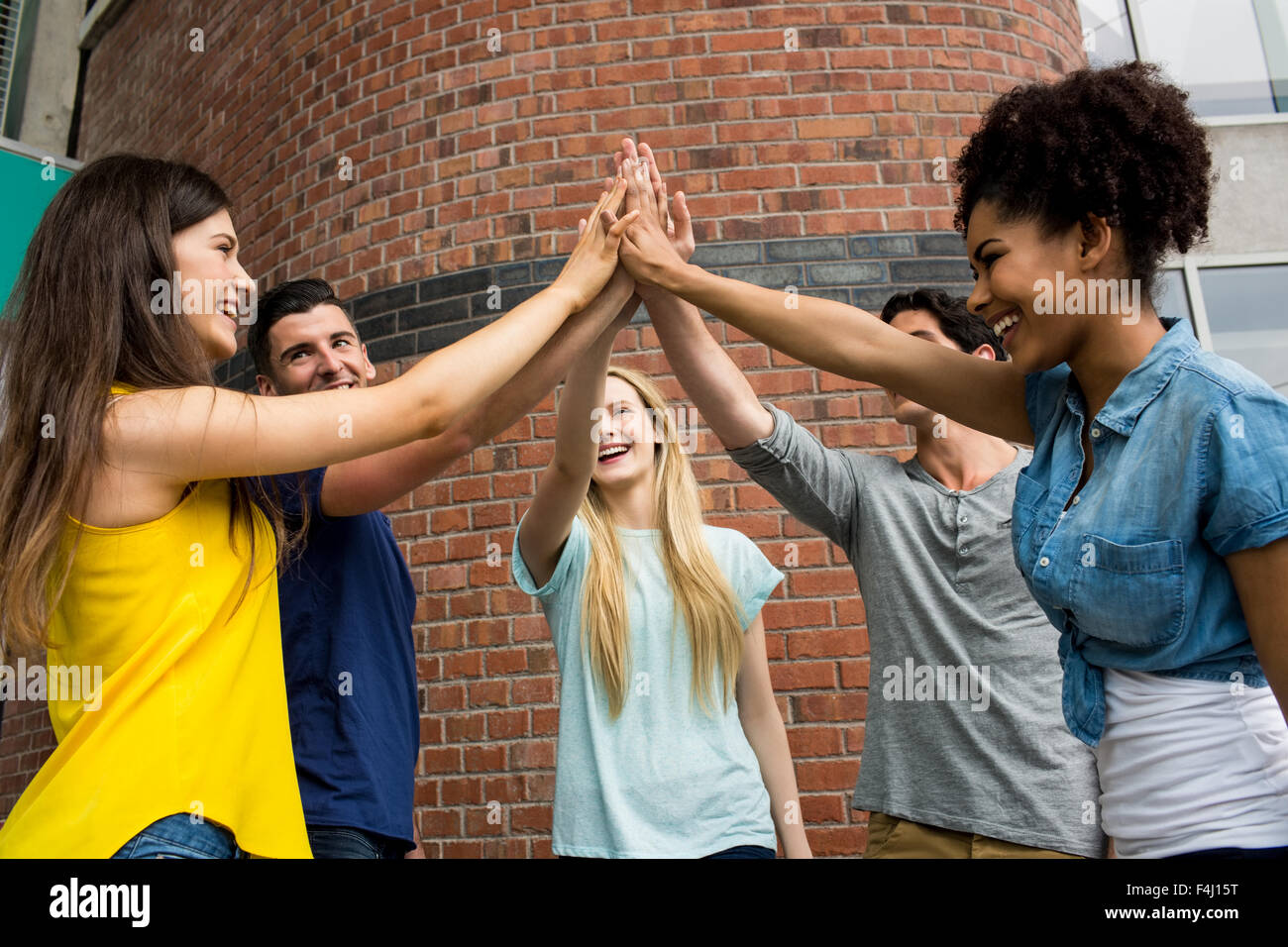 Gli studenti di mettere le mani insieme in unità Foto Stock