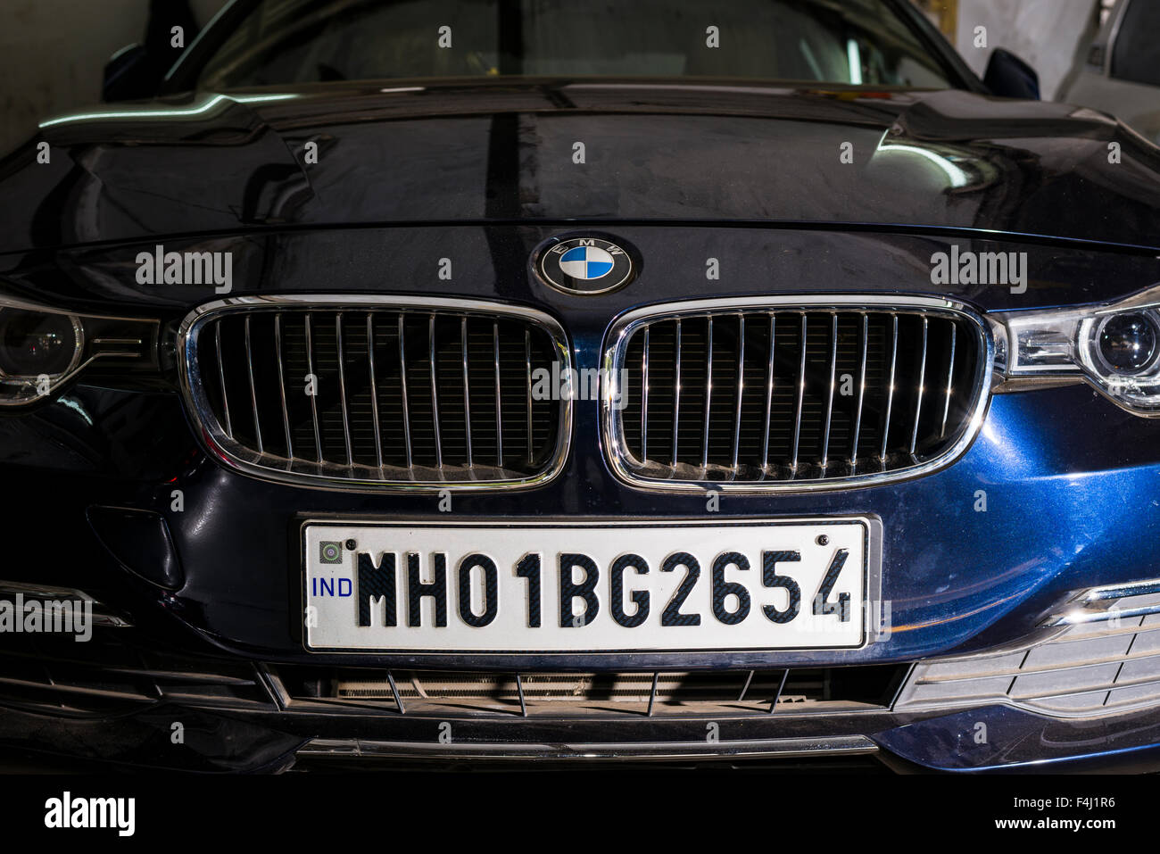 La parte anteriore di un tedesco della BMW auto con un numero di maharasthra piastra, un tipico simbolo di status per la ricca borghesia indiani Foto Stock