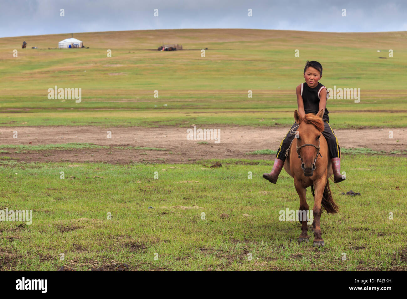 Cavallo e boy riding bareback con ger dietro ad estate campo nomadi, Khujirt, Uvurkhangai (Ovorkhangai), Mongolia centrale Foto Stock