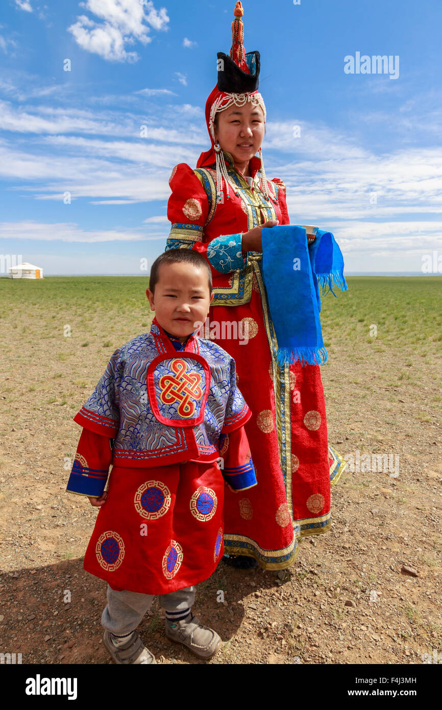 Donna e bambino in abito tradizionale (deel), argento ciotola per il messaggio di saluto di latte, vicino ger, deserto dei Gobi, Bulgan, Omnogov, Mongolia Foto Stock