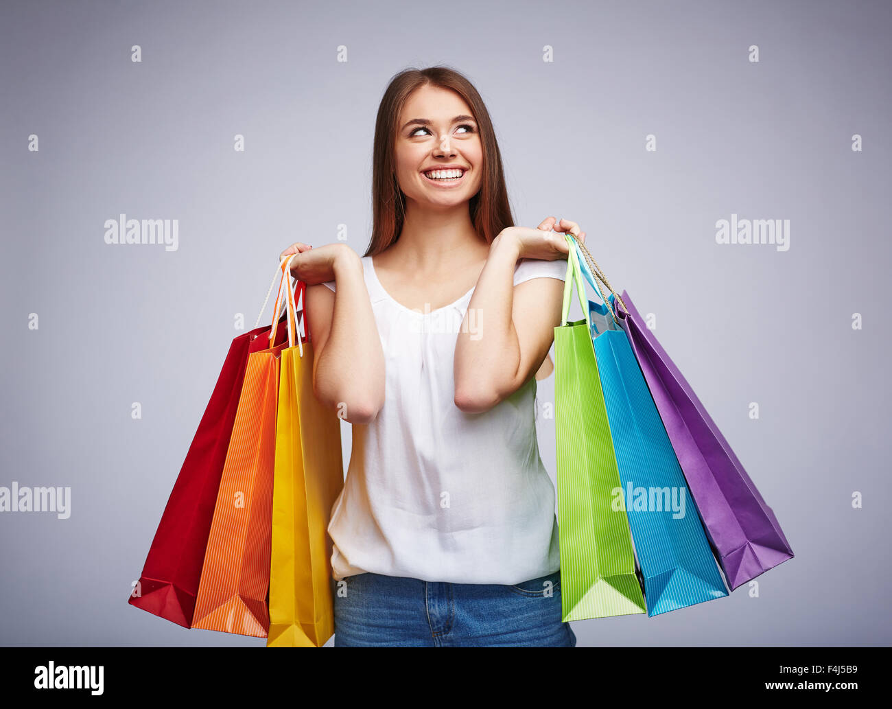 Consumatori soddisfatti che trasportano multi-colore paperbags Foto Stock