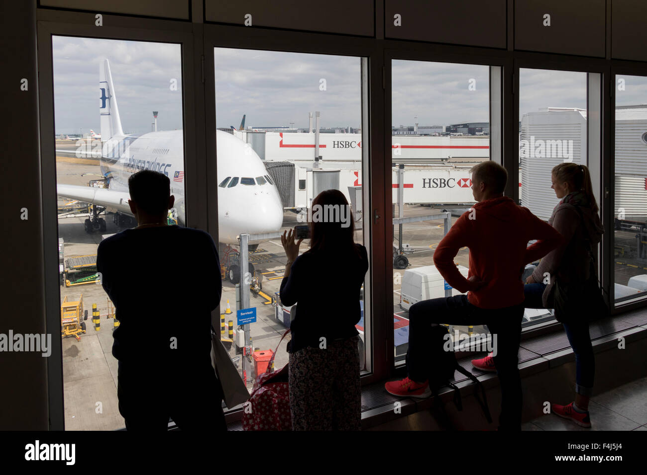 Persone di guardare attraverso una finestra in corrispondenza di un Airbus A380 della Malaysia Airlines presso l'Aeroporto Internazionale di Kuala Lumpur, Malesia Foto Stock
