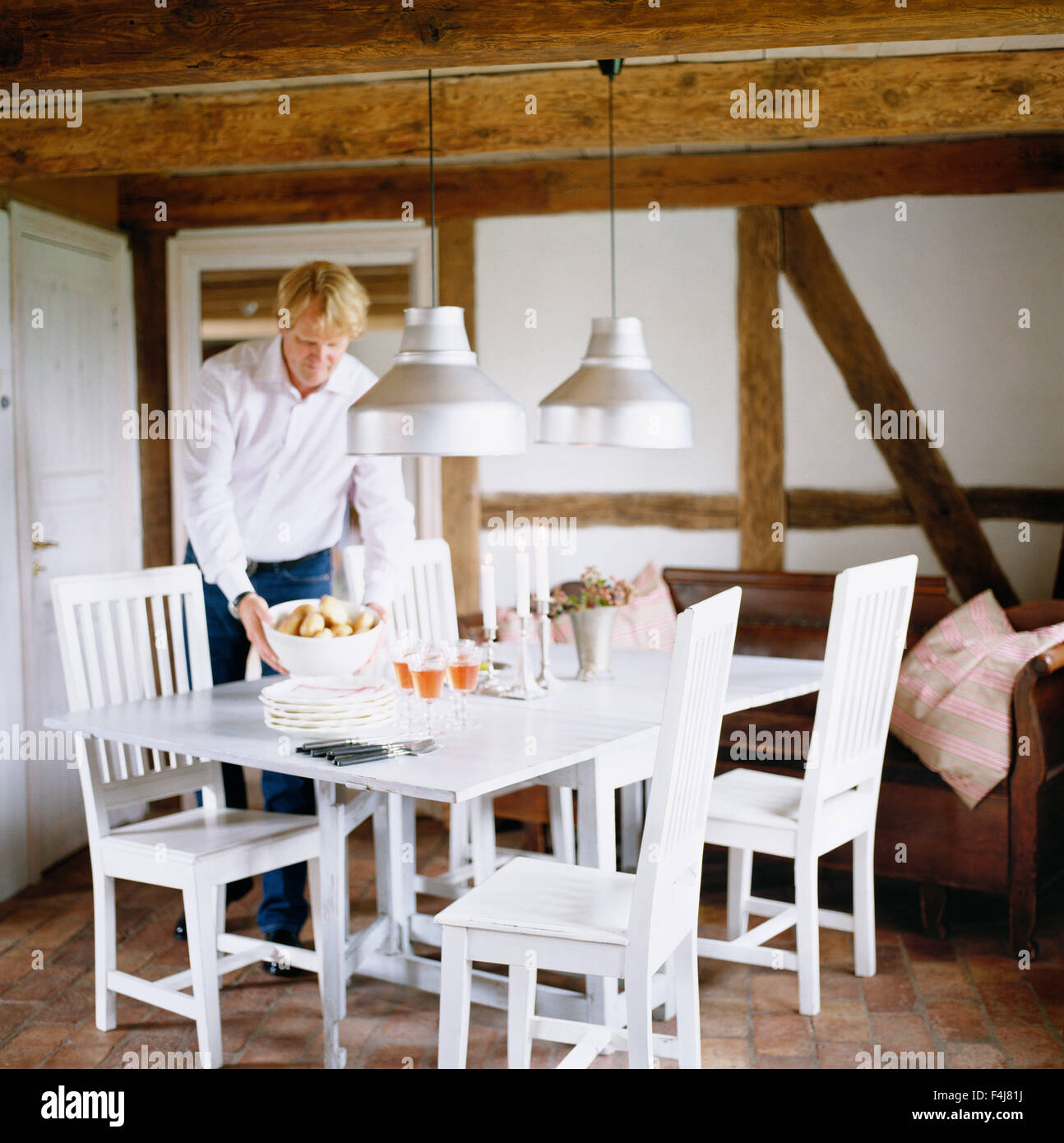 Un uomo impostazione della tabella. Foto Stock