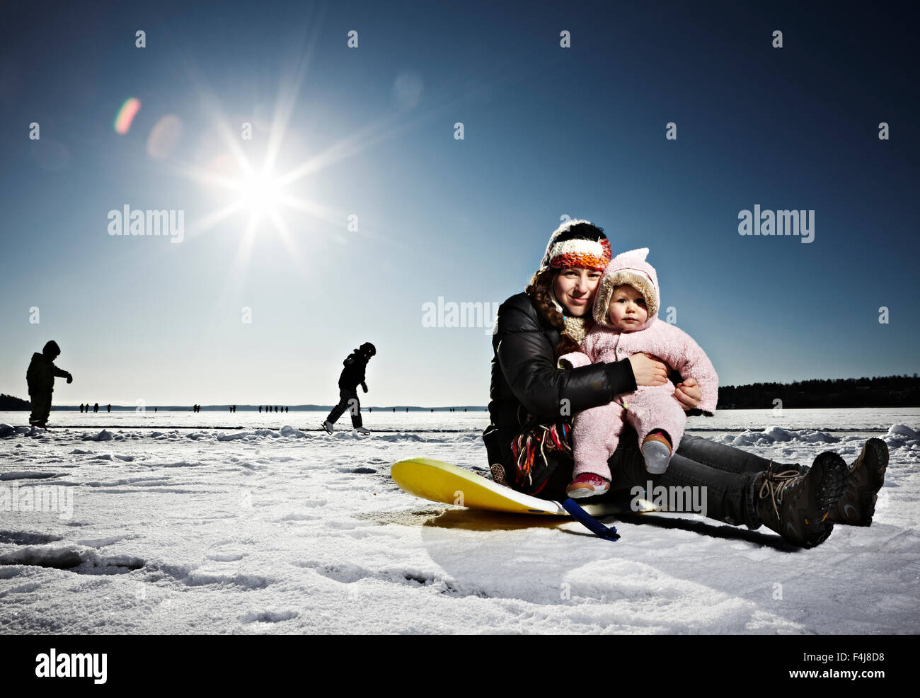 Madre e figlia del bambino seduto sul ghiaccio, Svezia. Foto Stock