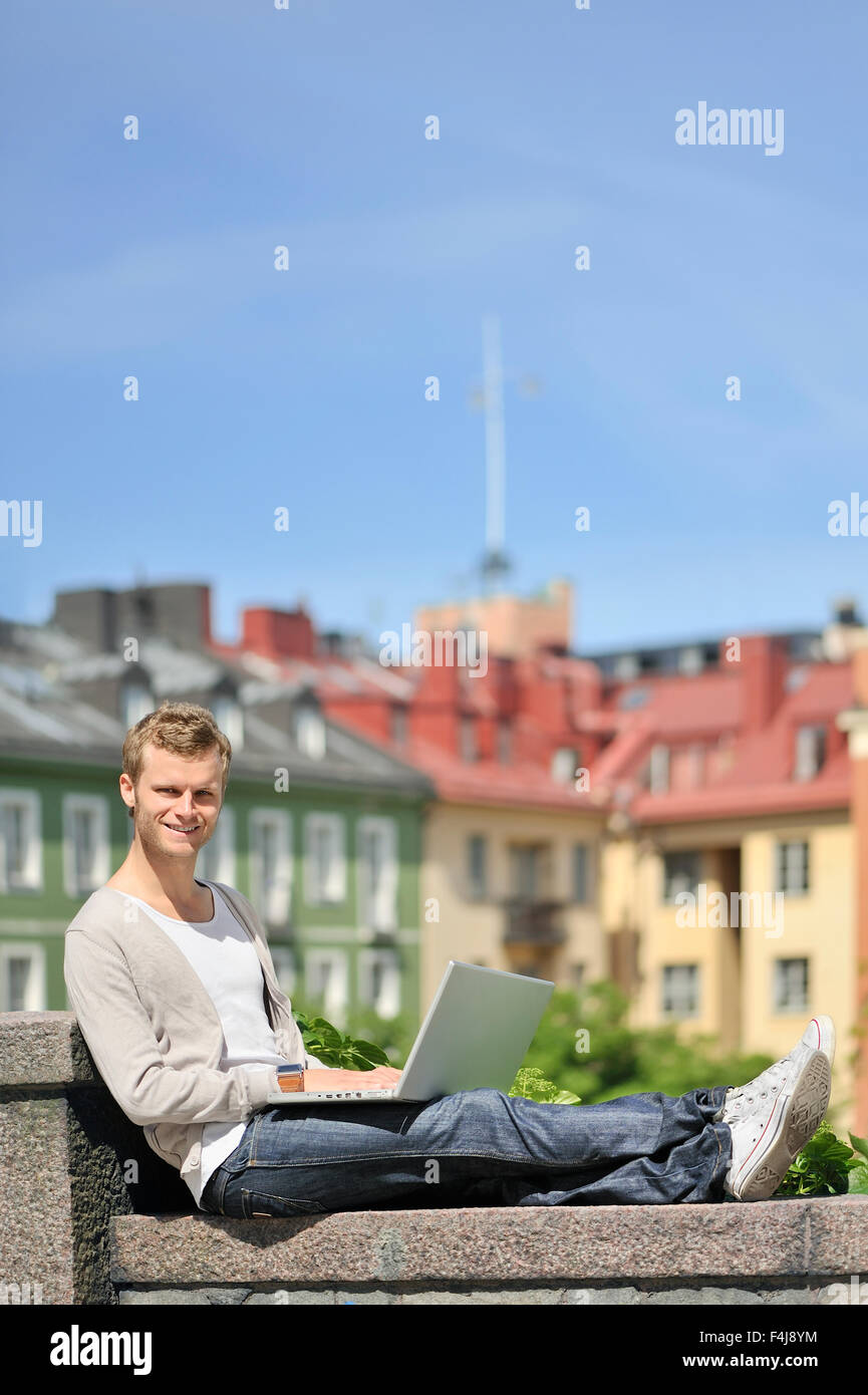 Un giovane uomo che utilizza un computer portatile, Svezia. Foto Stock