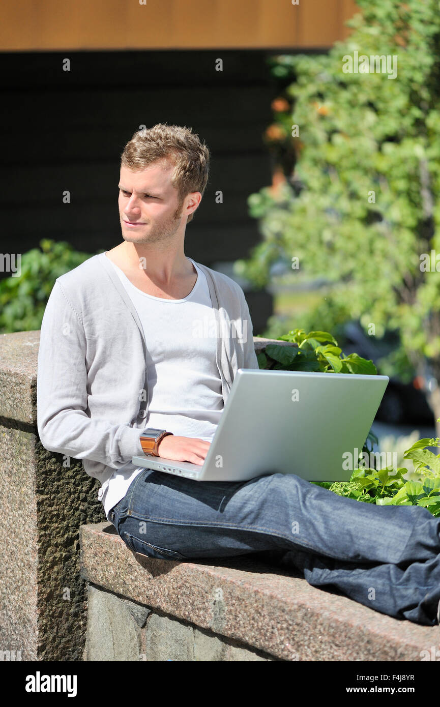 Un giovane uomo che utilizza un computer portatile, Svezia. Foto Stock