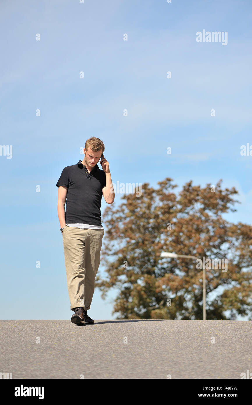 Giovane uomo a camminare su una strada, Svezia. Foto Stock