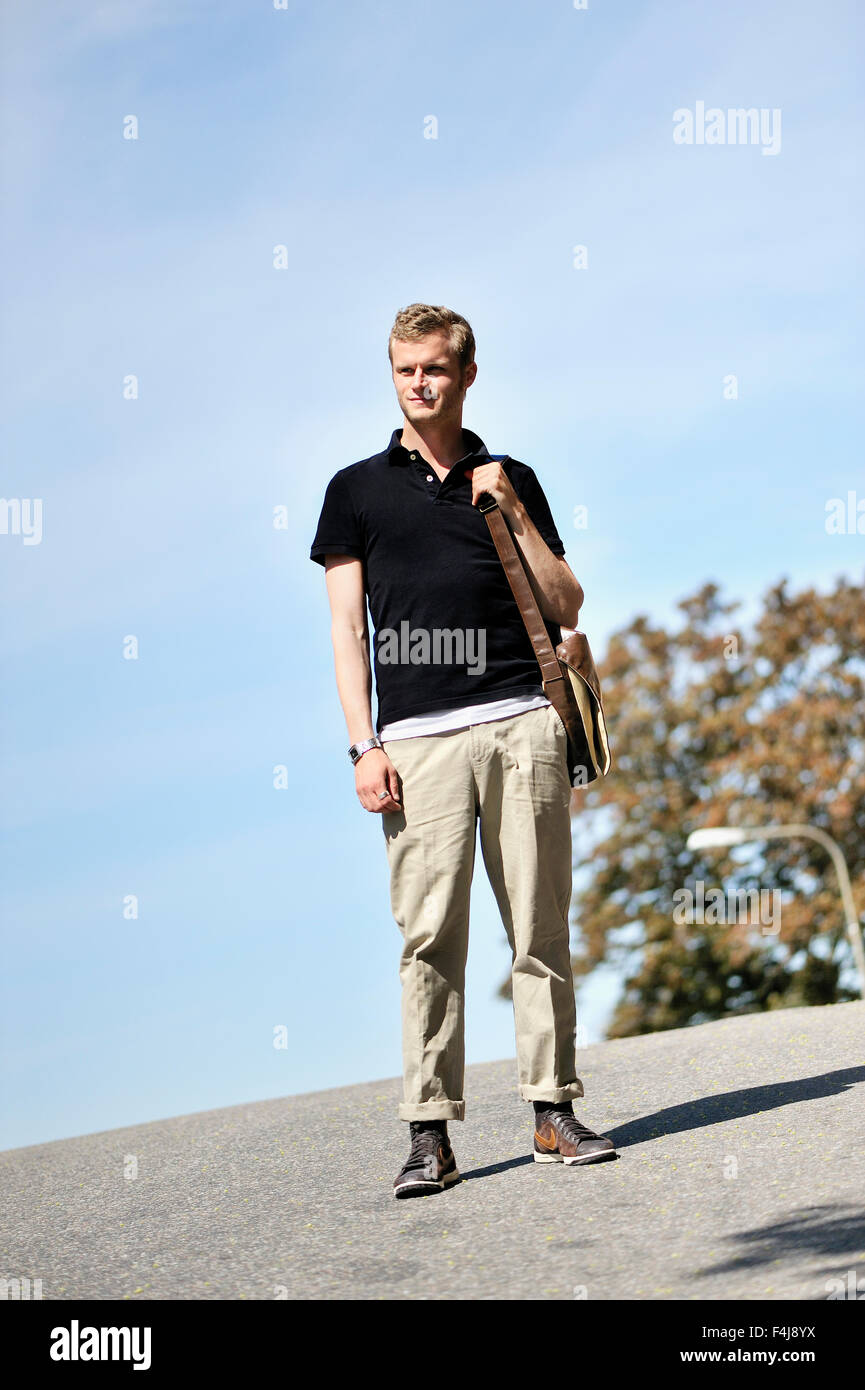 Giovane uomo a camminare su una strada, Svezia. Foto Stock