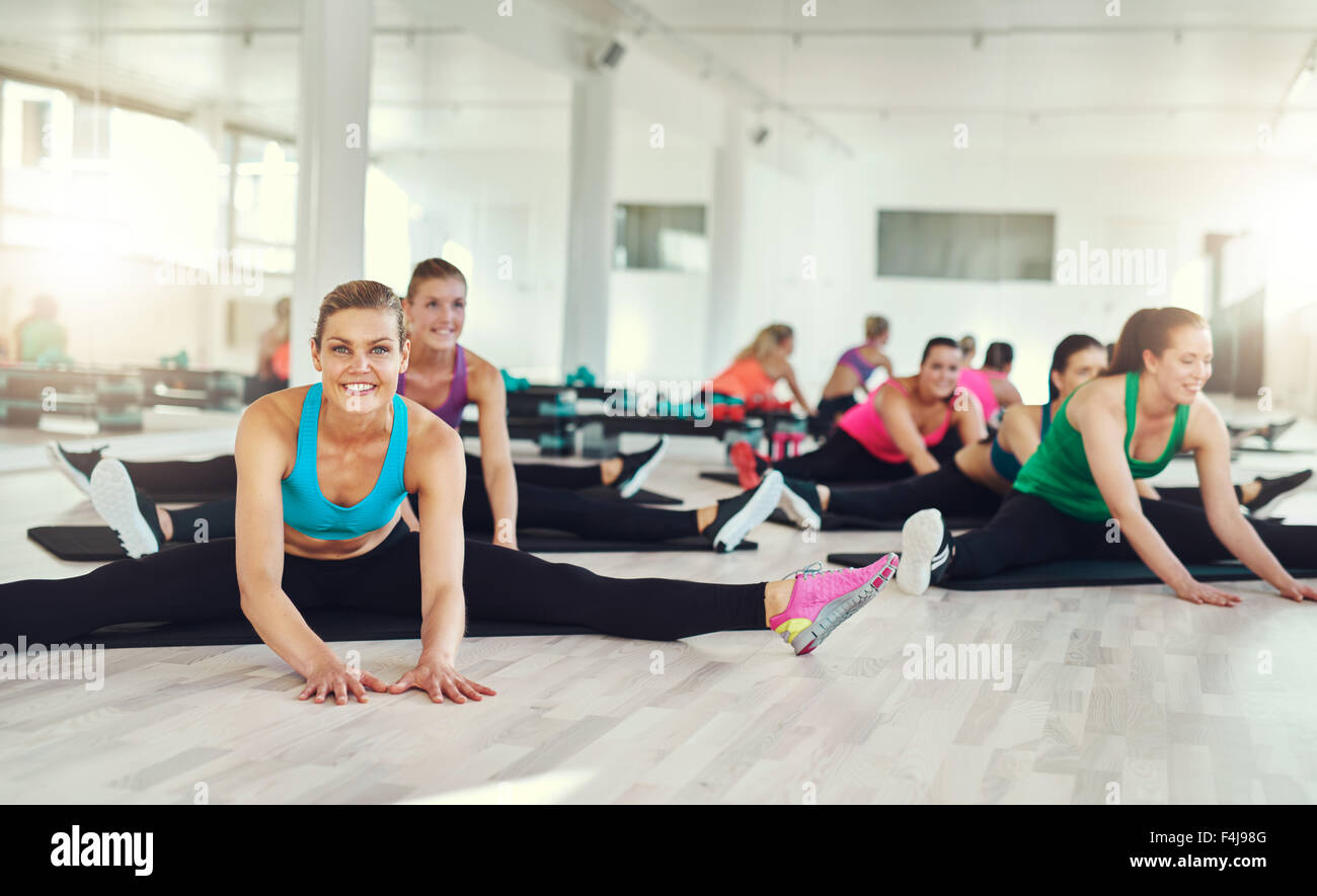 Gruppo di montare le donne di stiramento e di esercitare in una lezione di fitness, aerobica e concetto di fitness Foto Stock