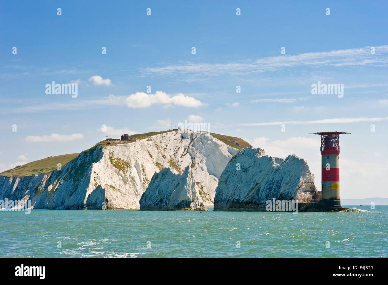 Gli aghi di una fila di tre distinte di pile di gesso che si ergono dal mare di estremità occidentale dell'Isola di Wight. Foto Stock